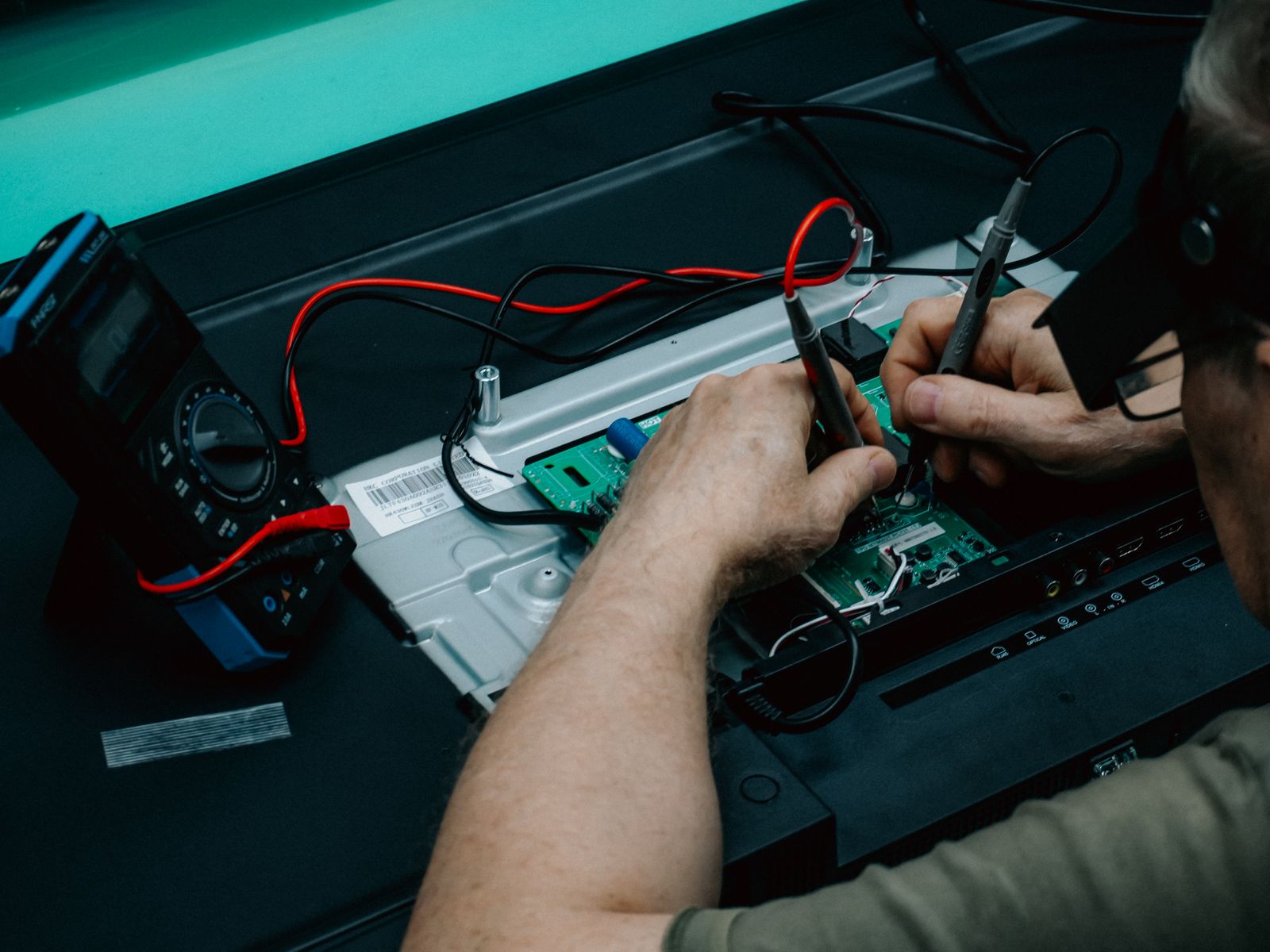 Technician using a multimeter to diagnose a TV with no power — TVCare Mumbai no-power repair service in Mira Road